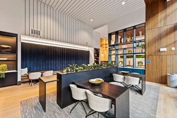 A modern dining area with a dark table and chairs.